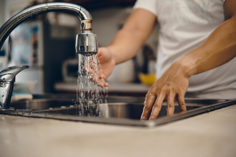 Cropped shot of an unrecognizable man washing his hands at home to prevent spreading of the coronavirus ( Covid-19)